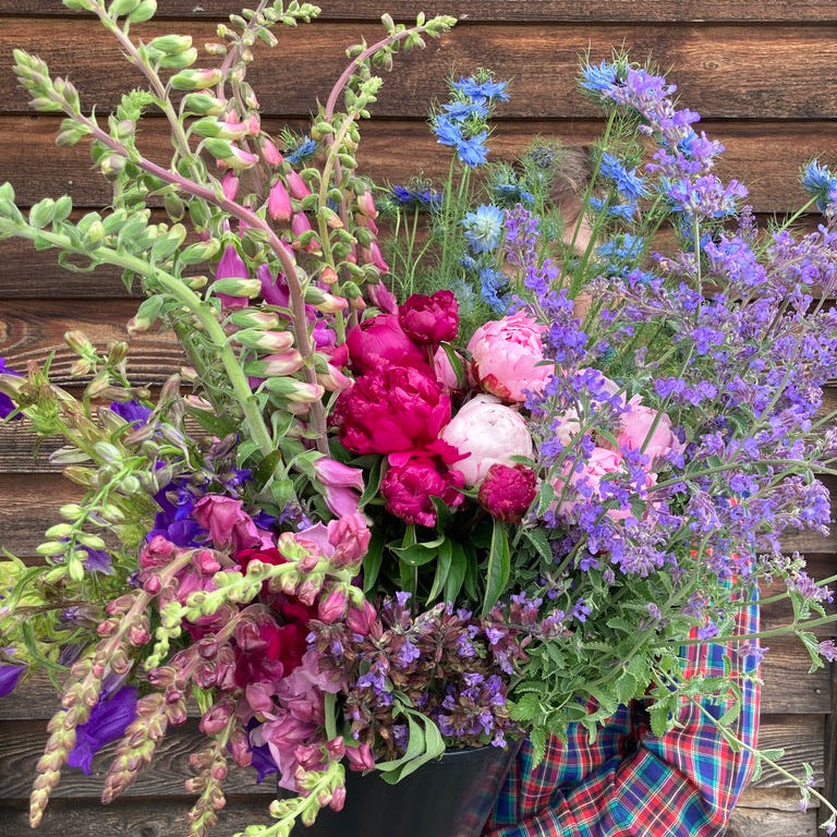 Bouquet of wildflowers held against a wooden background