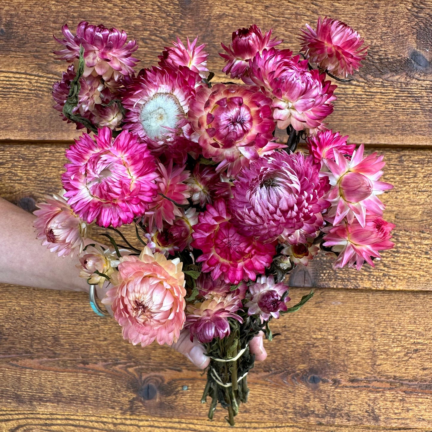 Bouquet of pink and purple flowers on a wooden surface